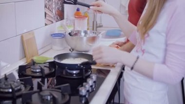 Genç çift mutfakta kendi kahvaltı hazırlarken.