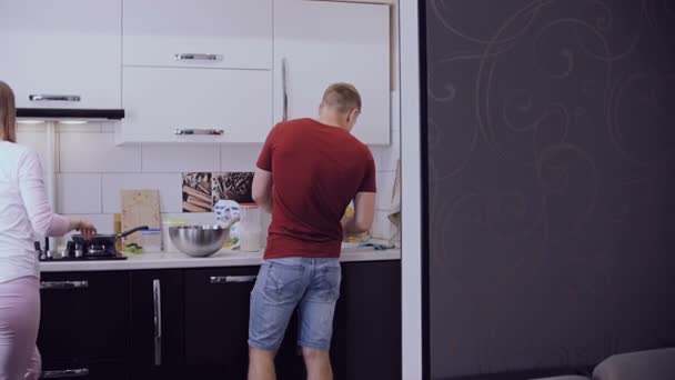 Joven pareja casada preparando el desayuno en su cocina . — Vídeos de Stock