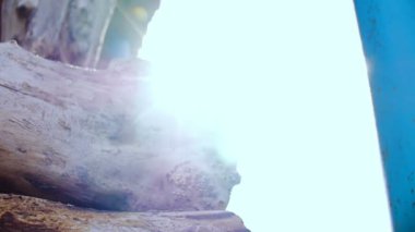 Yakacak odun dağının arkasından dışarı kamera peeks.