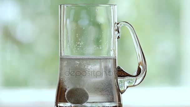 Una compressa cade nella tazza di birra con acqua . — Video Stock