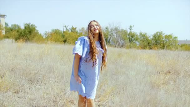 A young woman with long hair is dancing in the middle of the field. — Stock Video