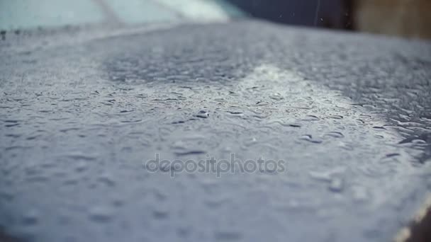 Regendruppels breken op het oppervlak van de auto. — Stockvideo