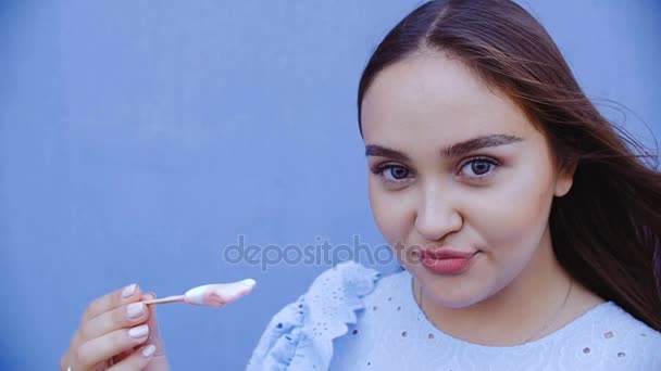 長髪の若い美しい女性がアイスクリームを舐める. — ストック動画