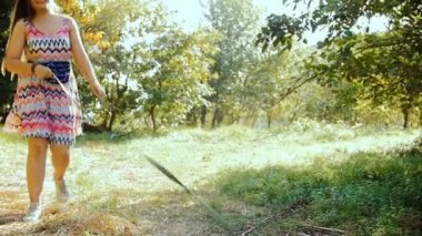 Genç bir kadın, yaz güneşli bir günde, bir husky köpek ormanıyla size yürür.