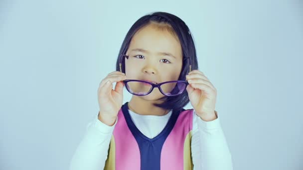 Ein kleines koreanisches Mädchen trägt eine Brille. — Stockvideo