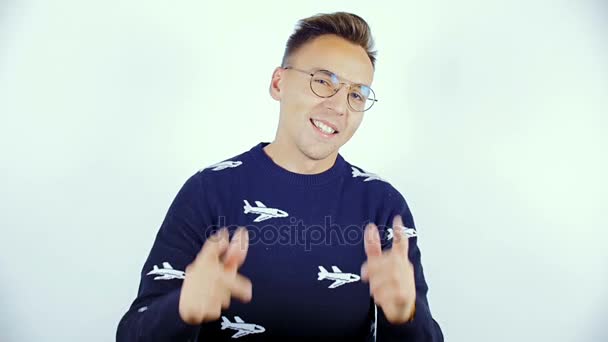 Un joven con un suéter azul y gafas en una sesión de fotos . — Vídeo de stock