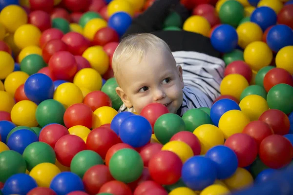 Pequeño niño alegre en bolas de colores — Foto de Stock