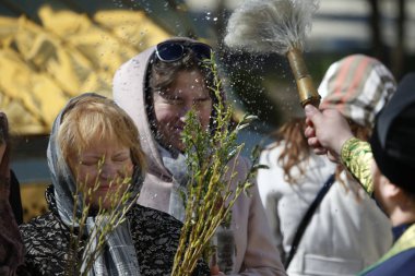 Belarus, the city of Gomel, the church of Peter and Paul 09,04,2017. Palm Sunday.The priest sanctifies the people with holy water by the sprinkler clipart