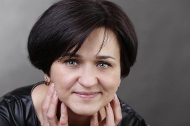 Bir kadın portresi gri bir arka plan üzerinde yaşlı. Elli bir kadın. Güzel bir genç kadının portresi yaşlı. Sıradan bir kadın