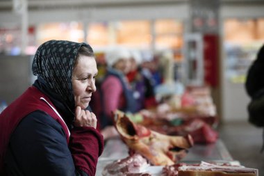 Beyaz Rusya, Gomel, gıda market, domuz bir Fularlı yaşlı bir kadın 13 Ocak 2017 satıyor. Et satışı. Et ürünleri pazarının