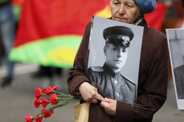 Beyaz Rusya, Gomel, 9 Mayıs 2017 Zafer Bayramı kutlama. Bir kadın savaş sırasında ölen asker bir babanın fotoğrafını taşır. Sevilen bir kaybı. Bir asker ölümü.