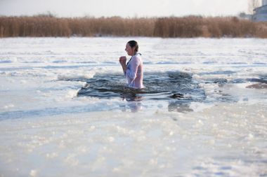 Beyaz Rusya, Gomel, 19 Ocak 2017. Lake Chernoye. Epiphany.Bathing Tanrı vaftiz, buz deliğe. Bir kadın Soğuk suya daldırma