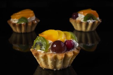 kivi meyve şeftali bektaşi yakın çekim siyah bir arka plan ile kek sepeti