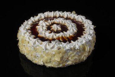 Beyaz çikolatalı kek ve siyah bir zemin üzerine tereyağı krema ile dekore edilmiş