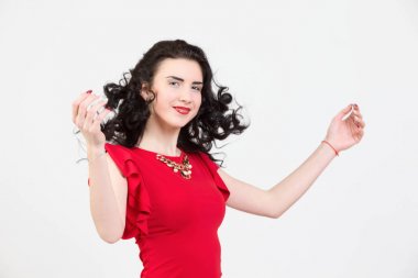 Saç ve eller yukarı uçan ile kırmızı bir elbise içinde parlak esmer