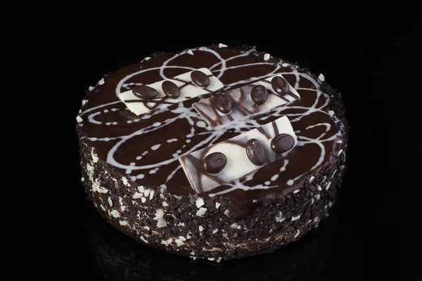 Chocolate cake with coffee beans on a black background