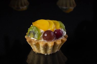 kivi meyve şeftali bektaşi yakın çekim siyah bir arka plan ile kek sepeti