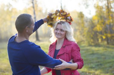 Sonbahar parkında sevgili bir çift. Yürüyüş için orta yaşlı eşler. Erkekler ve kadınlar dışarıda sarılıyorlar.