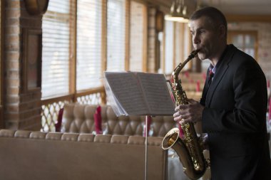 Belarus, Gomel şehri, Nisan 06, 2019. Halka açık yemek odası. Bağış etkinliği. Saksafoncu bir saksafon restoranında çalıyor.