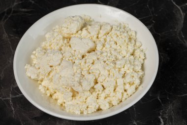 ahşap bir masa üzerinde süzme peynir ile plaka