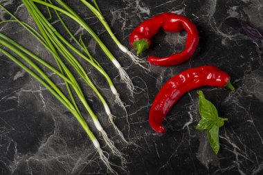 Gri arka planda salata için sebzeler. Kırmızı biber ve soğan, limon. Parlak sebzelerin yaşamı