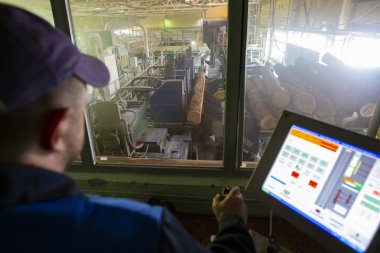 Belarus, Gomil şehri 29 Nisan 2019. Ahşap işleme tesisi. Ahşap işleme endüstrisi. Ağaç kesme dükkanı. Bilgisayardaki işçiler odunları kesmeyi kontrol ediyor.