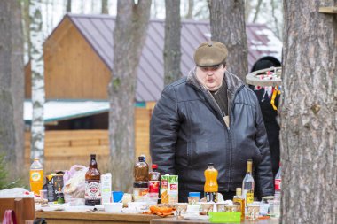 Belarus, Gomel şehri, 25 Şubat 2017. Tatil için şehir dışına. Sokaktaki şişman adam yemeği düşünüyor..
