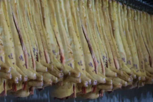 Blurred meat factory. A lot of pork carcasses in a meat processing factory.