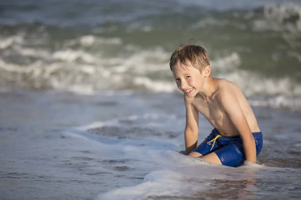 海の近くの楽しい少年は波と遊ぶ ビーチで休んでいる子供 — ストック写真