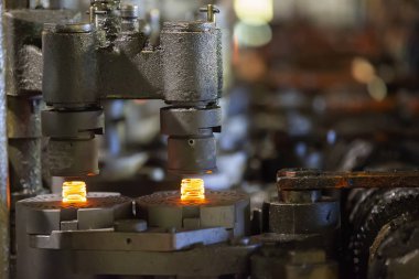 Cam fabrikası. Cam endüstrisi. Cam şişe üretimi için makine taşıyıcısı.