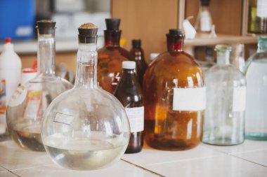 Laboratuvar masasında cam mataralar. Eczane konteynırları eski.