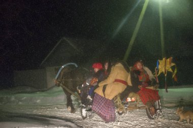 Belarus, Gomil şehri, 13 Ocak 2019. Cömert bir akşam ayini. Kalyada töreni. Eski yılbaşı arifesinde Slav halk festivali. At arabasındaki etnik takım elbiseli insanlar Noel şarkıları söylemeye gidiyor.