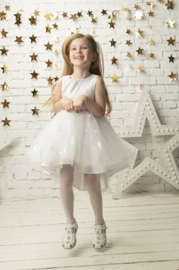 Zarif elbiseli, dikey neşeli küçük kız. Komik çocuk..