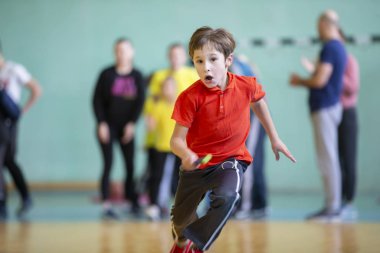 Çocuk spor salonunda. Beden eğitimi dersinde bir öğrenci. İlkokulda bayrak yarışı. Çocuk spora gidiyor. Çocuk eğitimi. Spor Günü.
