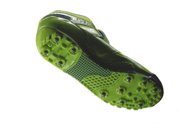 Beyaz arka planda çivili spor ayakkabılı yeşil taban. Spor ayakkabılar..