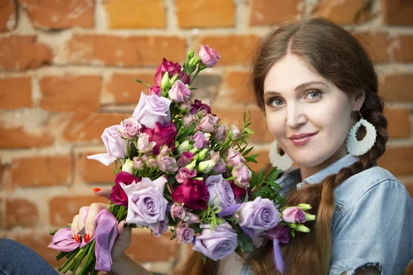 Mooi Meisje Met Een Boeket Van Bloemen Een Baksteen Muur — Stockfoto