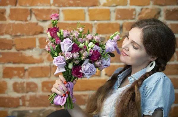 Mooi Meisje Met Een Boeket Van Bloemen Een Baksteen Muur — Stockfoto