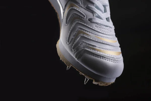 Siyah Arka Planda Dikenleri Olan Beyaz Bir Spor Ayakkabısı Parçası — Stok fotoğraf