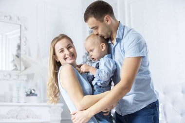 Noel 'de aile. Anne ve baba bir Noel ağacının arka planında oynuyorlar. Anne ve baba ve oğul yeni yılda.