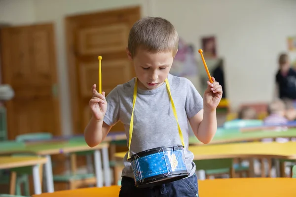 少年はおもちゃの太鼓を演奏する 才能ある少年未来の音楽家 — ストック写真