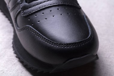 Siyah deri bir botun parçası. Koyu renk ayakkabılar..