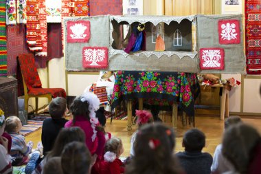 Belarus, Gomil şehri, 24 Aralık 2016. Noel zamanı. Batleyka kukla gösterisi. Çocuklar Belarus etnik tiyatrosunu izliyor.