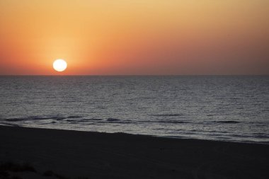 Denizin arka planında yükselen güneş manzarası