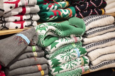 Mağazada Noel süsleri olan kazaklar. Katlanmış örgü yığını.