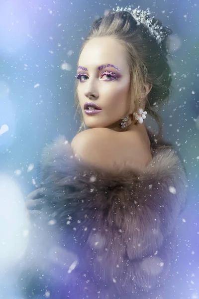 The Snow Queen. Winter girl in a fur coat showered with snow. Mo