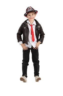 Beyaz arka planda, sekiz boyunda, şık bir çocuk. Şapkalı çocuk kırmızı kravatlı deri ceket. Komik ilkokul öğrencisi..