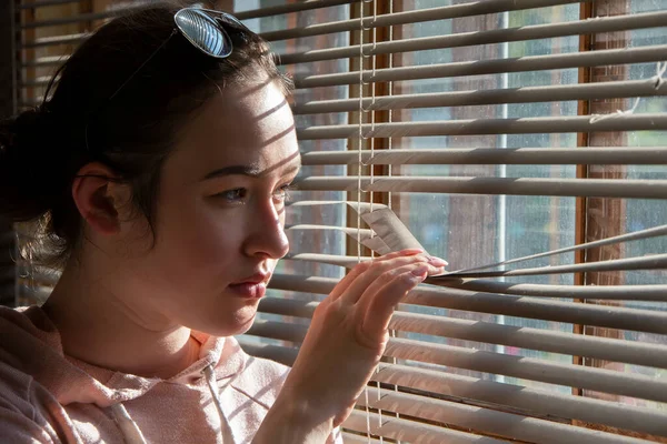 Girl Looks Out Window Blinds — Stock Photo, Image