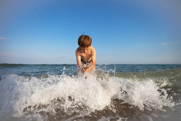 休暇中の子供 海の少年が波と戯れる — ストック写真