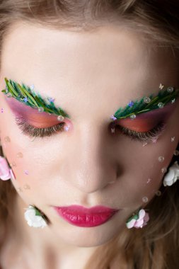 Makyaj kaşları ve kirpikleri olan güzel bir kız.