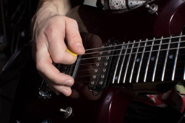 El gitar çalar. Dizgilerin üzerinden özyinele.